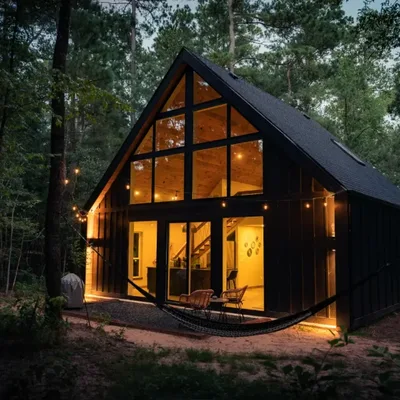 Coyote cabin at Lost Forest Cabins, lit from inside at dusk