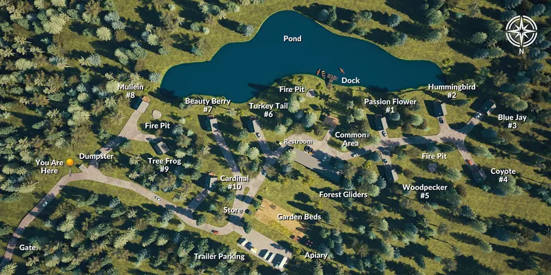 Aerial map of Lost Forest Cabins showing the pond and dock, the ten cabins labeled by name and number, the fire pits, common area, restroom, store, garden beds, apiary, gate and trailer parking